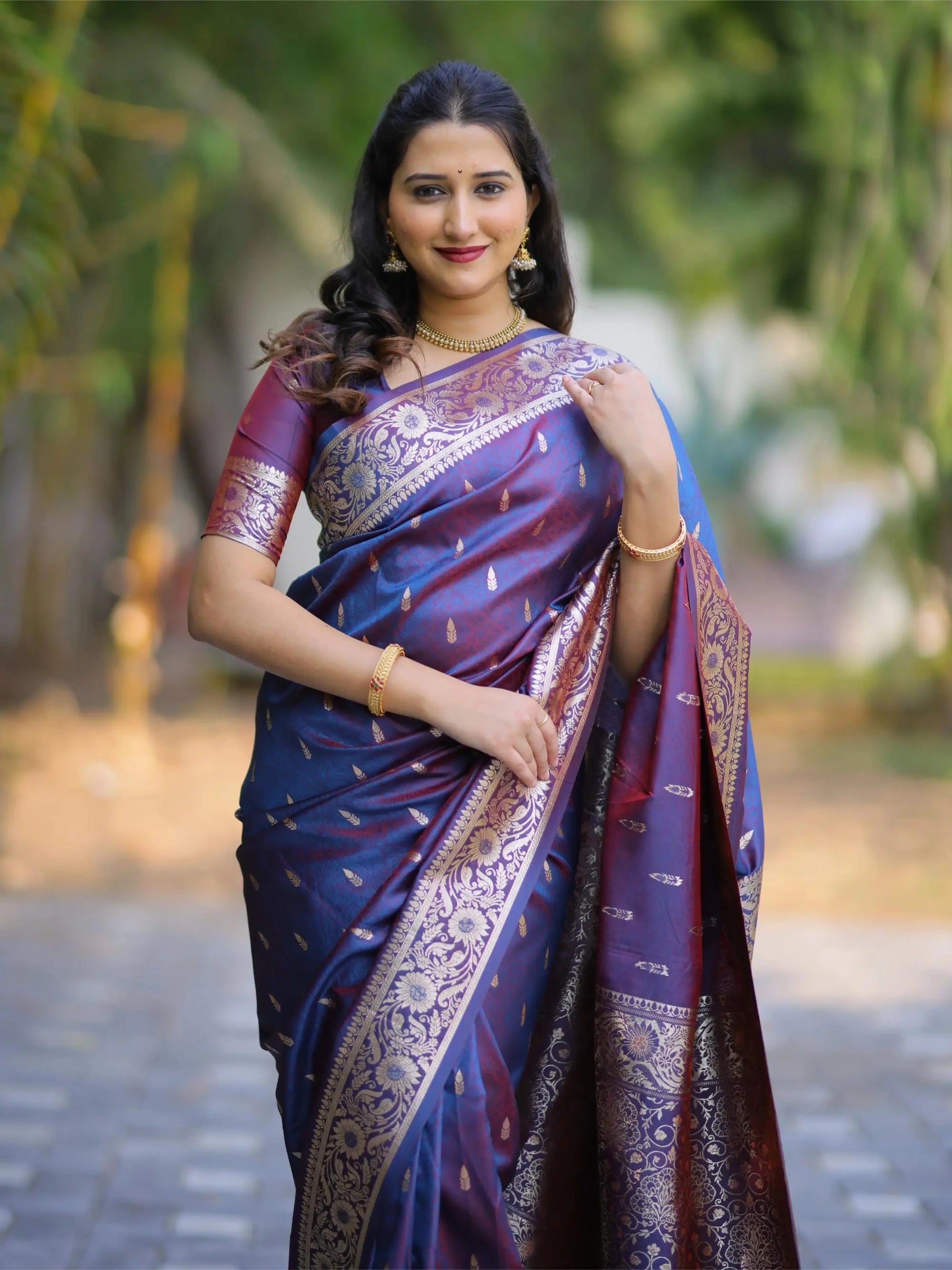 Woman wearing a traditional saree with a blurred natural background